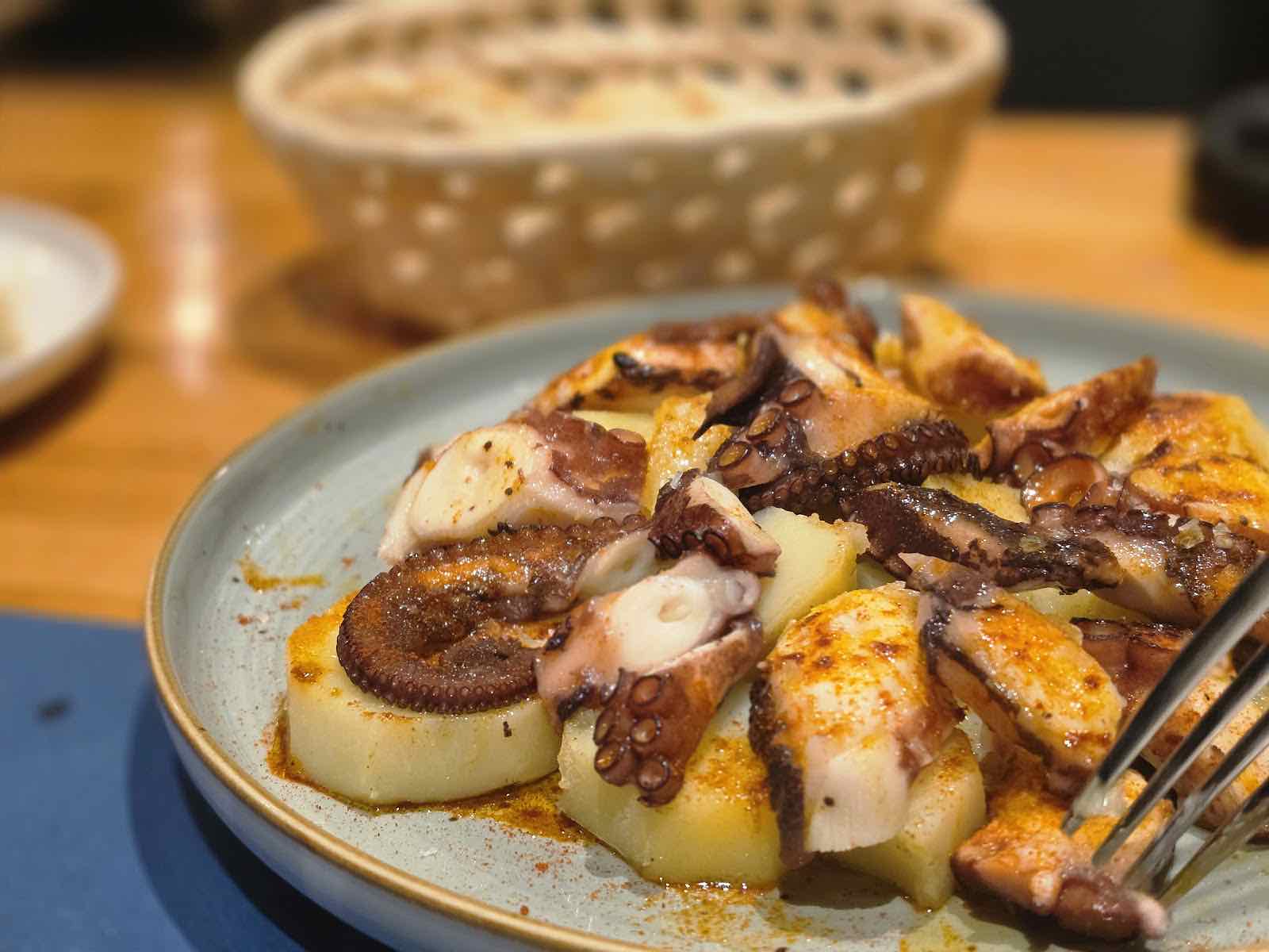 Pulpo a la plancha sobre patata cocida con pimentón en plato cerámico de Bikainn