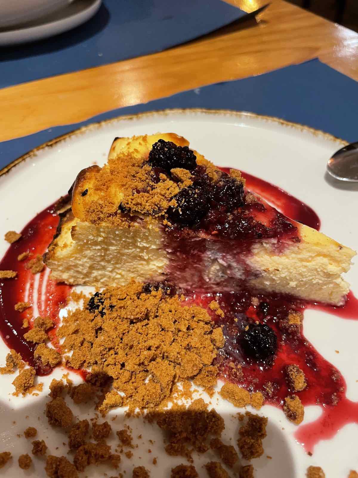 Tarta de queso casera con frutos rojos y galleta especiada en plato de Bikainn